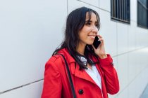Junge Frau schaut beim Telefonieren weg — Stockfoto