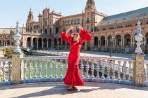 Жіночий художник фламенко танцює з піднятими руками на Плаза Де Ессана в Севільї, Іспанія в сонячний день. — стокове фото