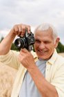 Glücklicher Senior fotografiert durch Kamera — Stockfoto