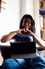 Smiling woman gesturing heart shape on video call through digital tablet at home — Stock Photo