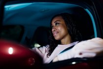 Sorridente donna guida auto di notte — Foto stock