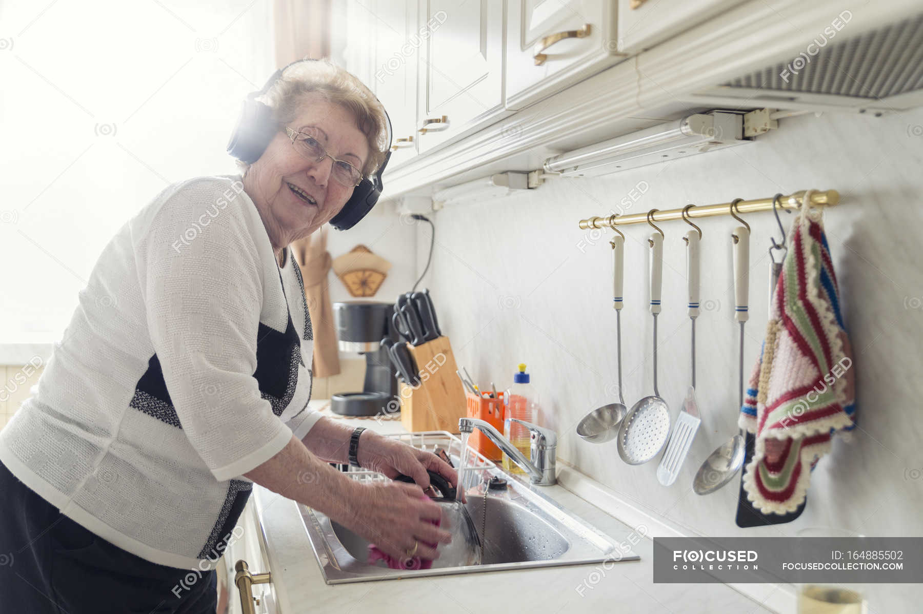 Песня моем посуду. Женщина моющая посуду. Пожилая женщина моет посуду. Бабушка моет посуду фото. Расстроенная пожилая женщина моет посуду.