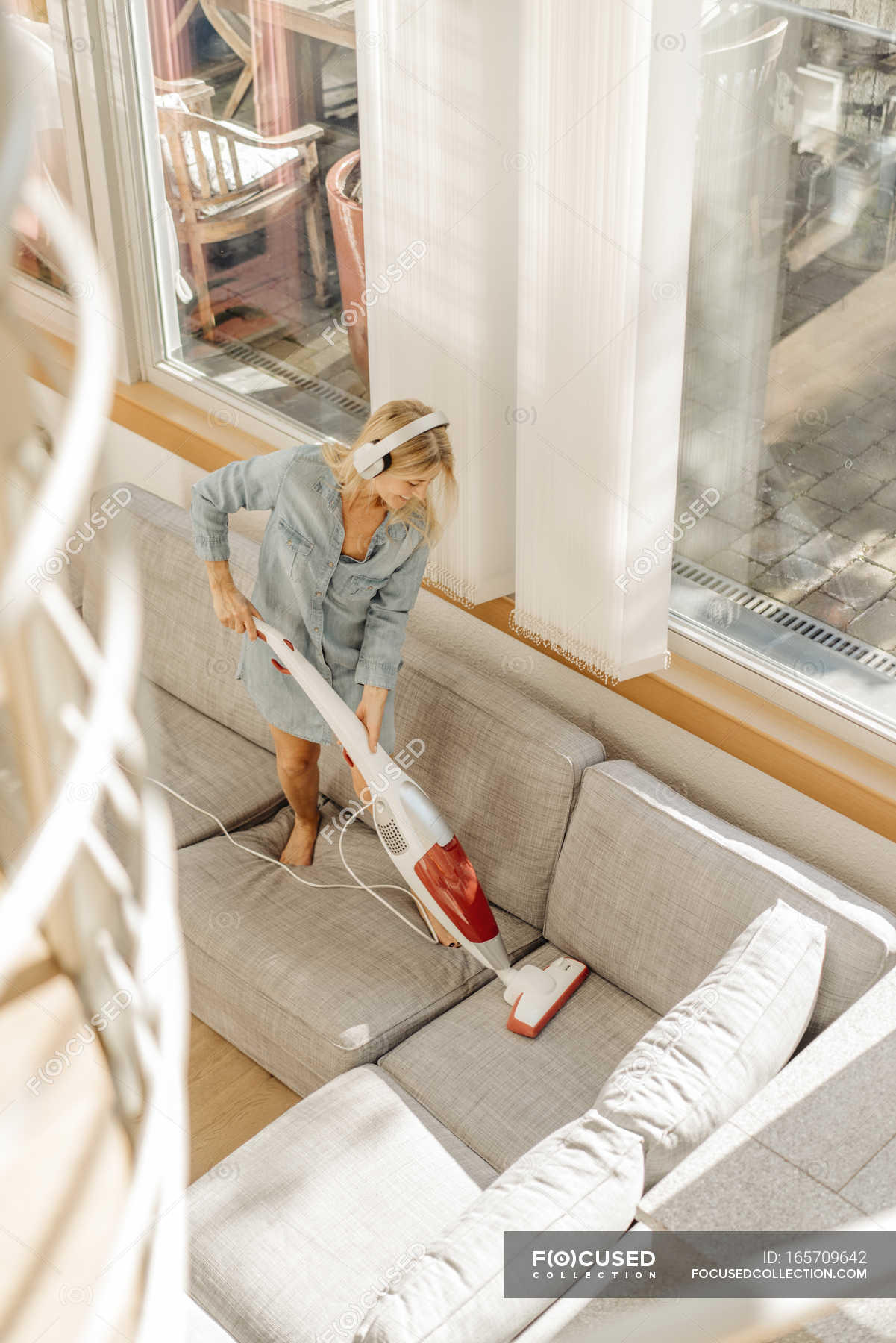 Woman Hoovering Couch Living Room Full Length Stock Photo