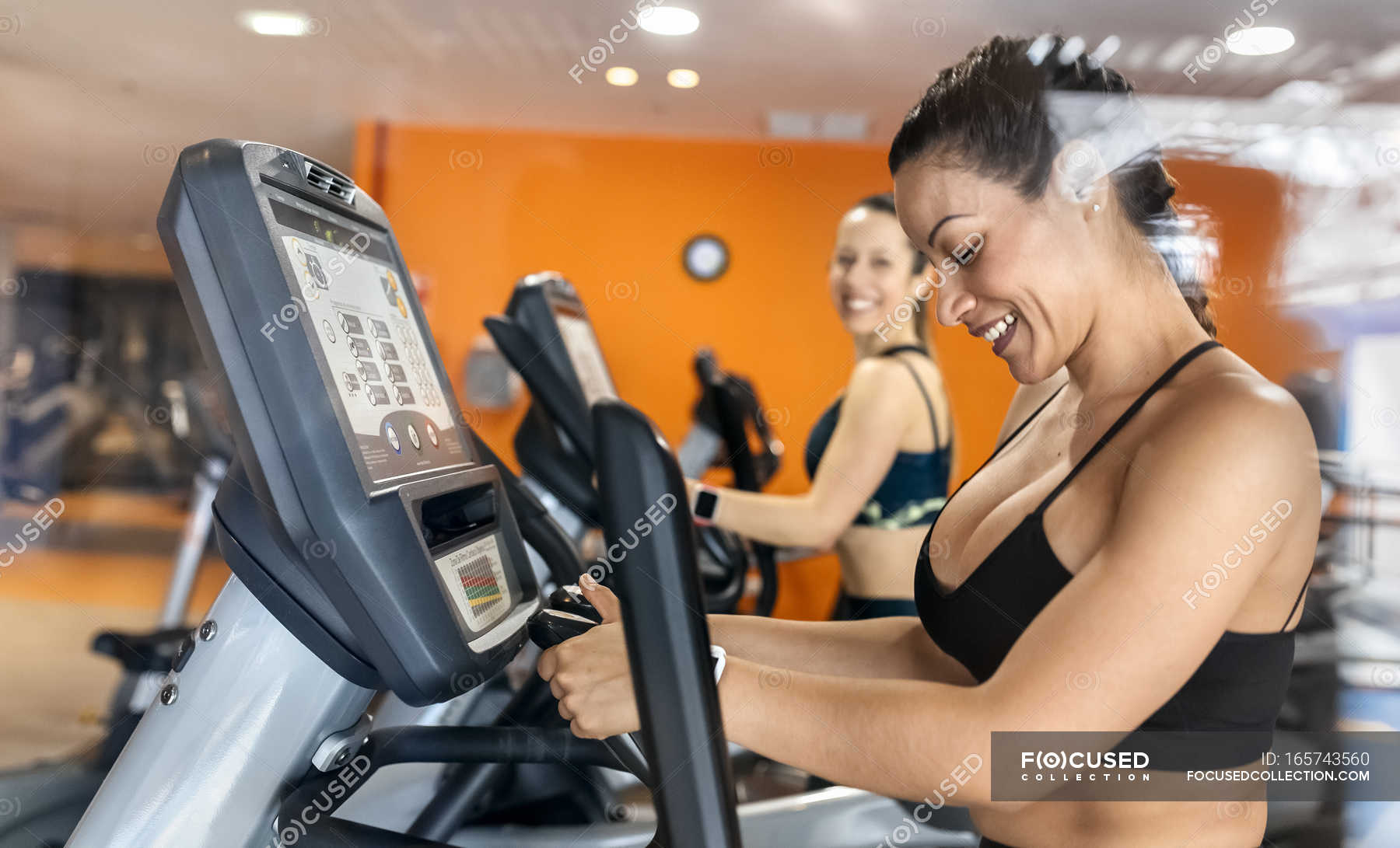 Women using elliptical trainers — 25 30 Years, joy Stock Photo