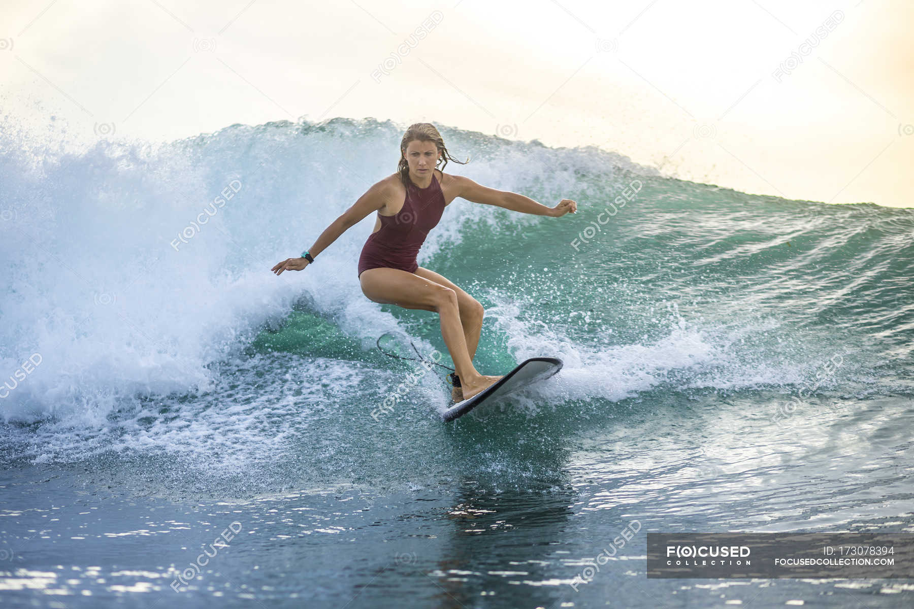 Indonesia Bali Woman Surfing On A Wave Full Length Sportive Stock Photo