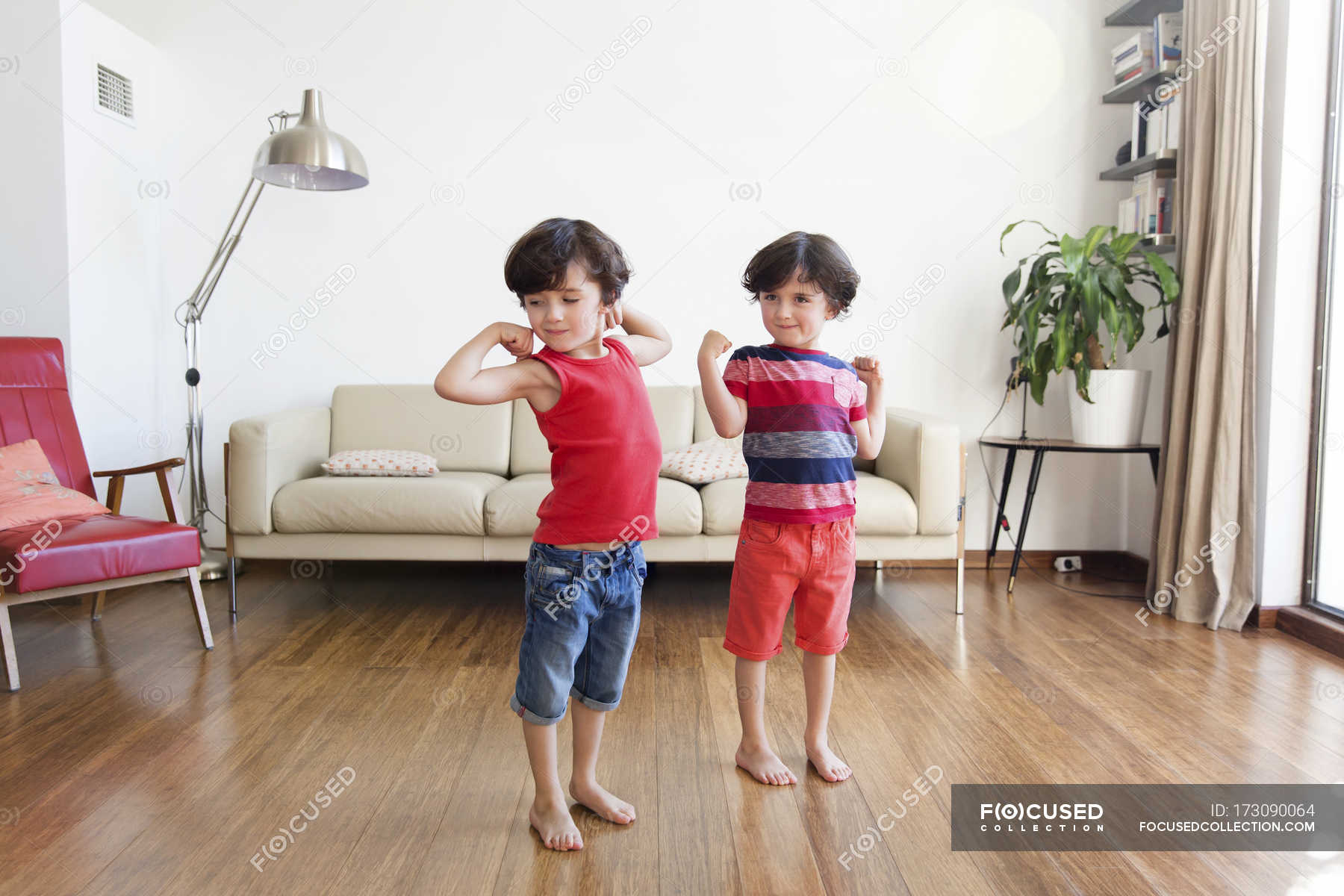 Twin Brothers Flexing Muscles Brown Hair Living Room Stock