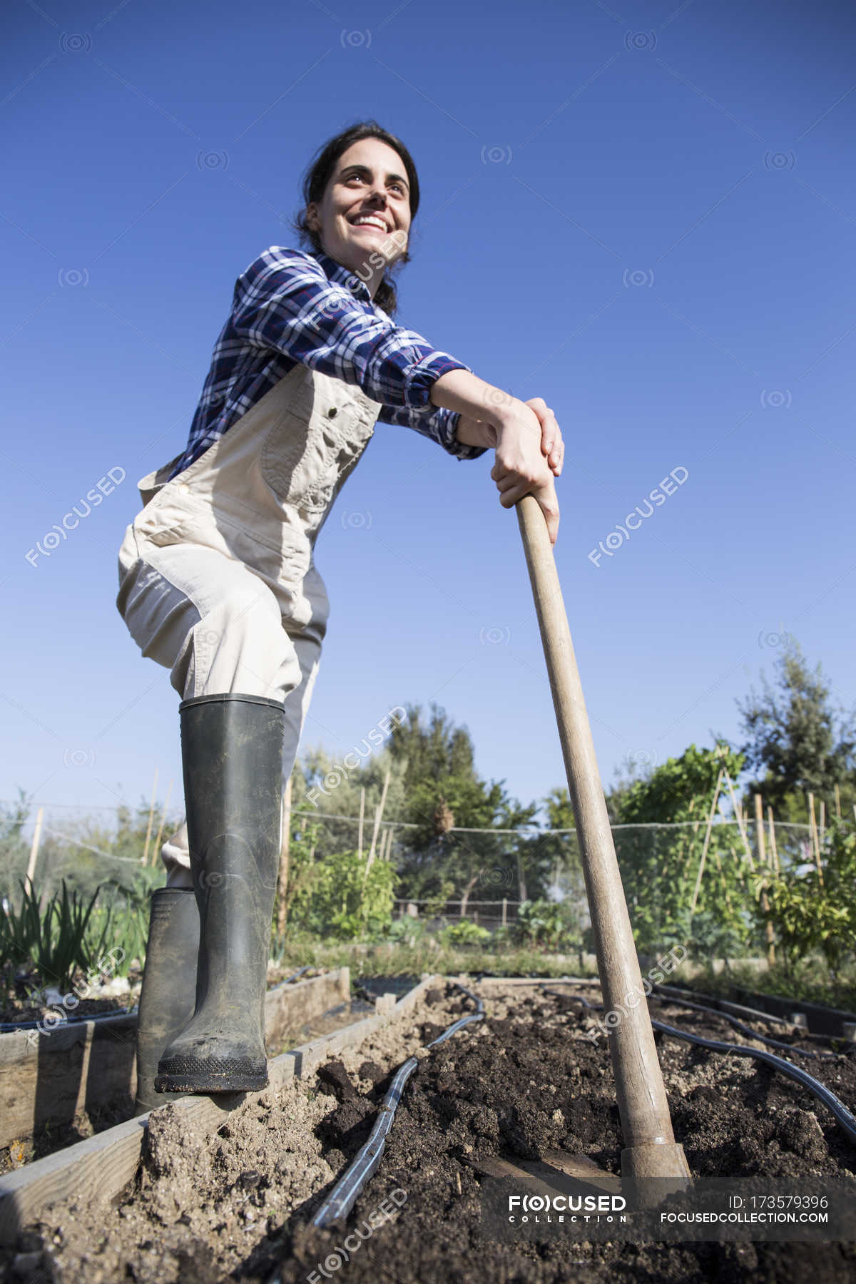 Woman Working On Farm Preparing Vegetable Patch Garden