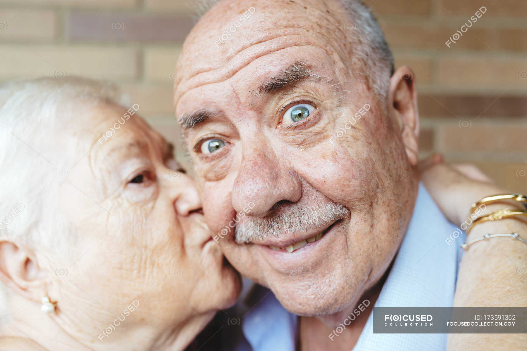 Senior man pulling funny face while his wife kissing him — smiling,  embracing - Stock Photo | #173591362