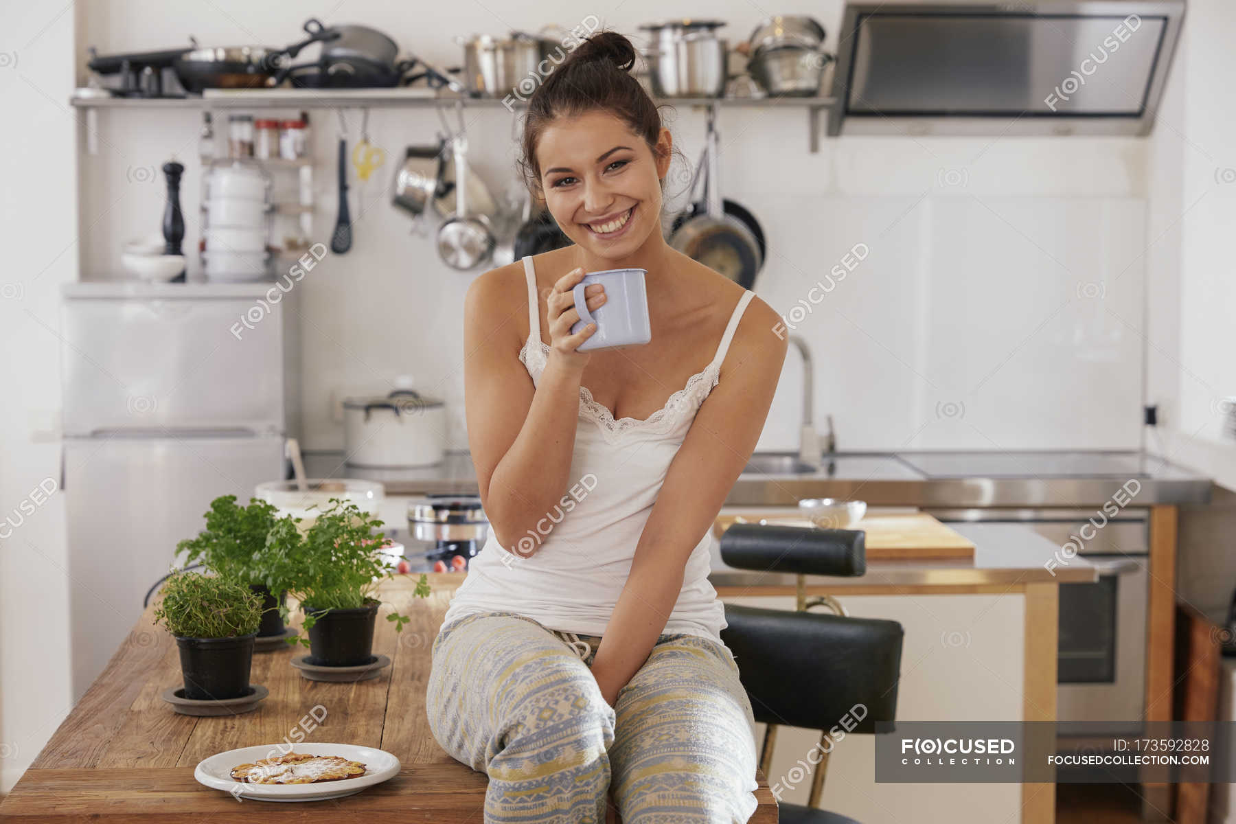 Попить на кухне. Девушка за столом на кухне. Женщина пьет кофе на кухне. Девушка на кухне с кофе. Девушки на кухне за чашкой кофе.