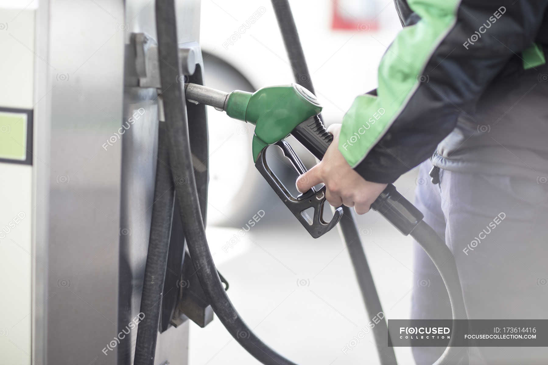 male-petrol-attendant-holding-petrol-pump-25-30-years-man-stock