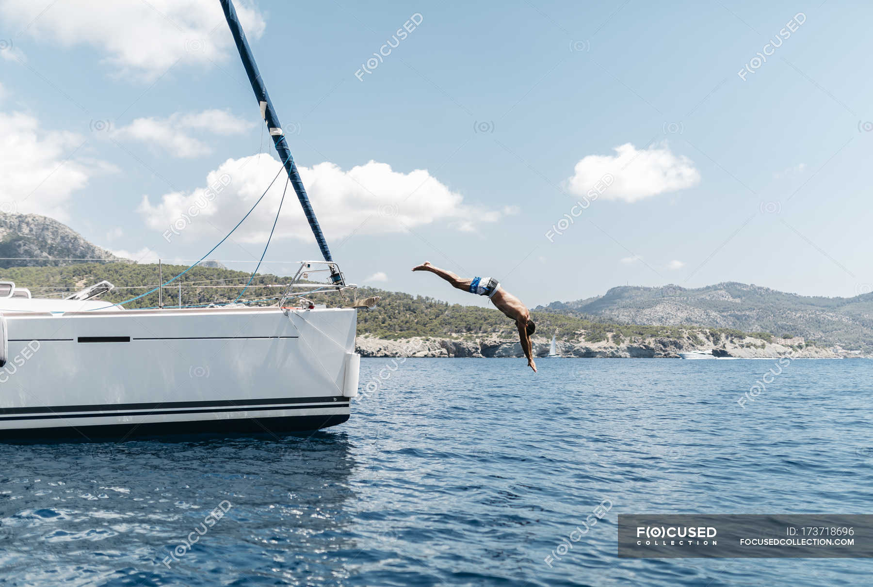 Man jumping from his sailing boat into the sea — recreation, summer