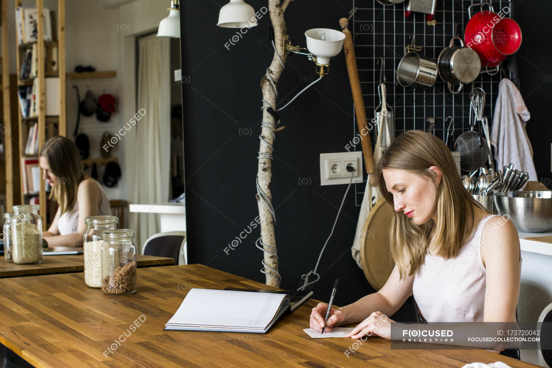 She sat at the table. Девушка сидит за столом и записывает. Девушка сидит за столом и записывает на камеру. Девушка что-то записывает. Фото девушка чтото записывает дома.