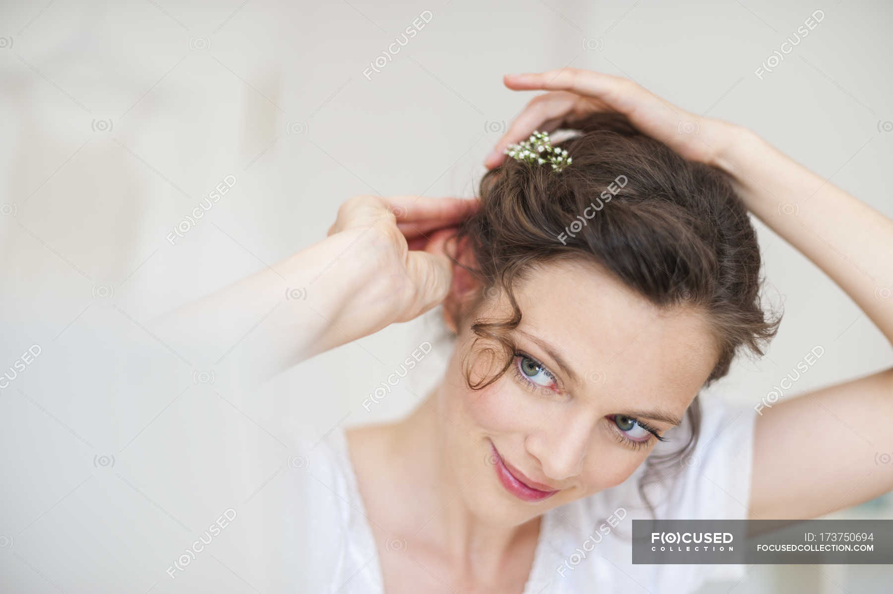 Close-up of Woman putting flowers in hair — beauty, attractive - Stock  Photo | #173750694
