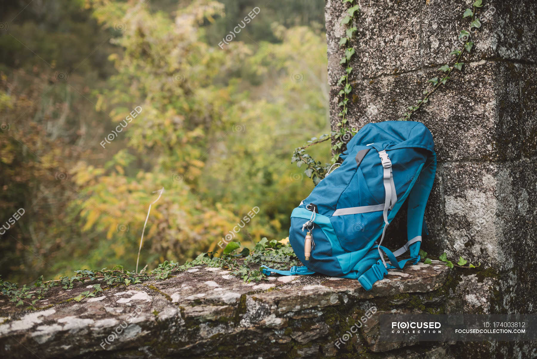 Blue backpack on a stone wall in nature ??? resting, forest Stock Photo