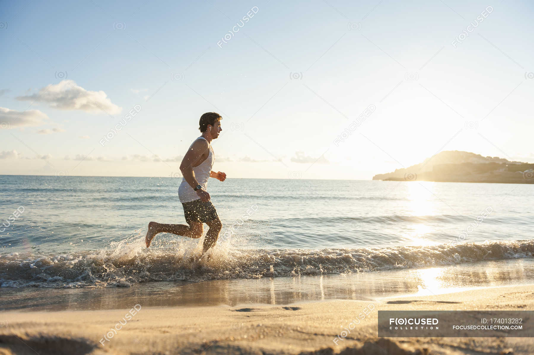 Young man jogging beach in sports wear, fit - Stock | #174013282