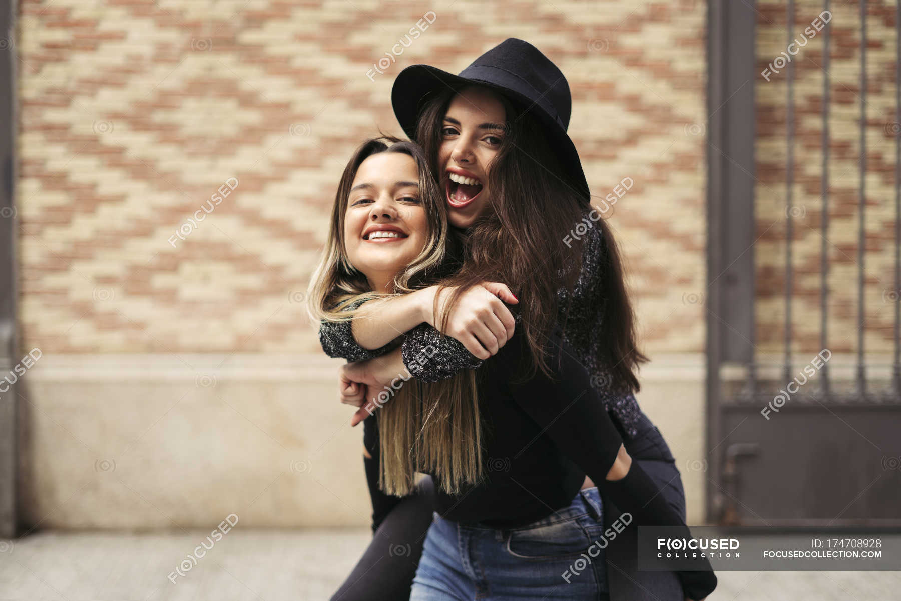 Girl giving her friend a piggyback ride stock photo