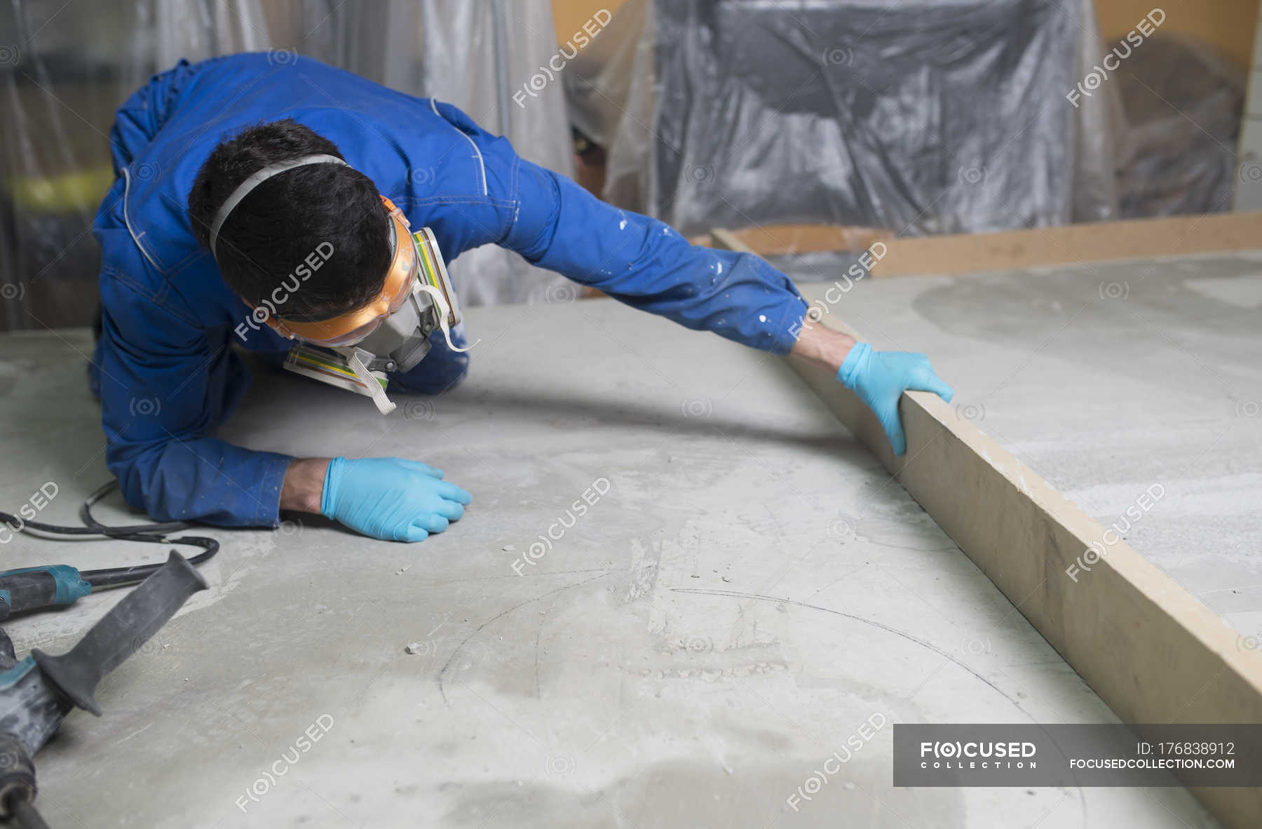 Worker Checking The Level Of The Concrete Floor Work Wear