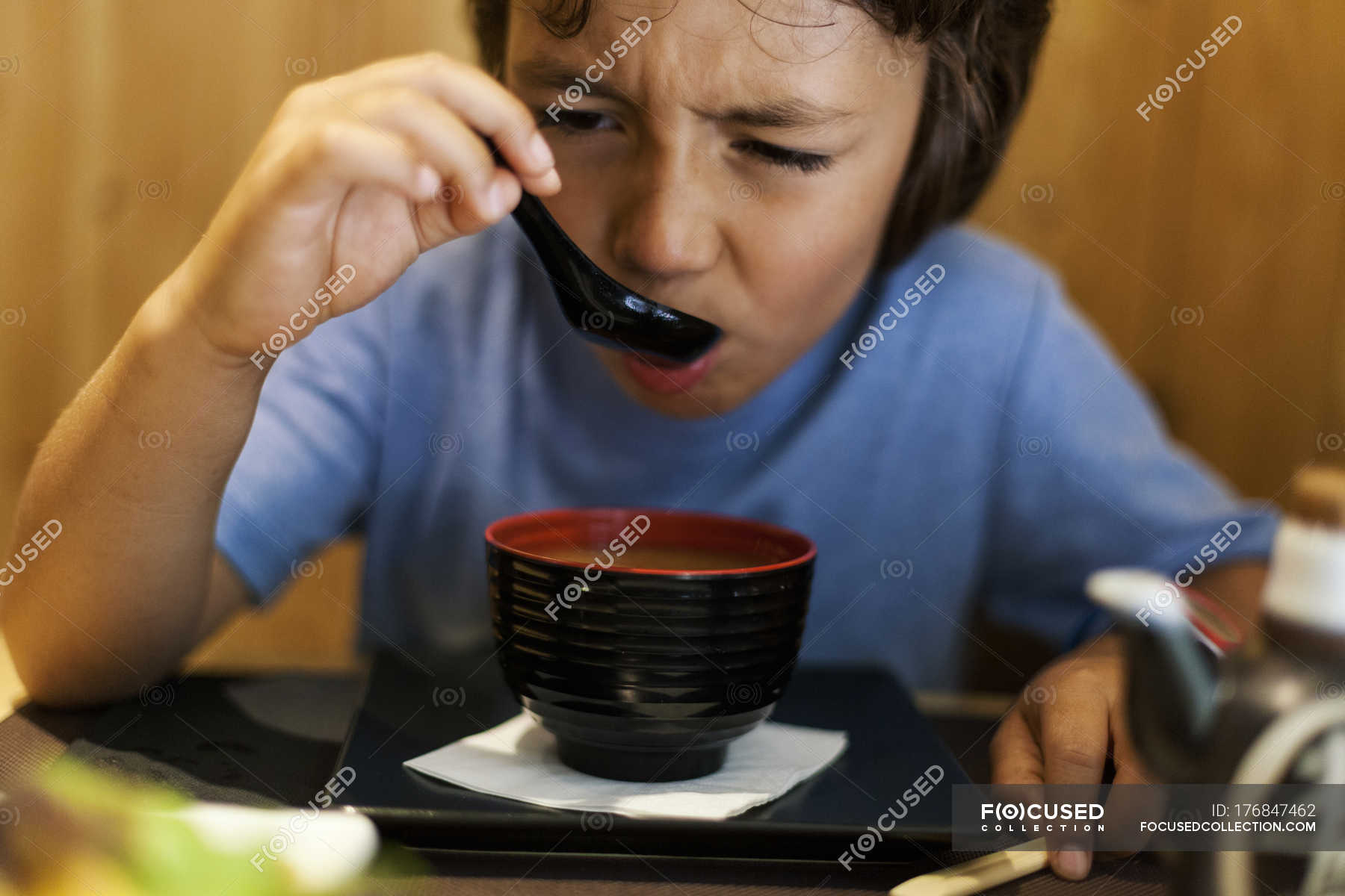 little-boy-sitting-in-an-asian-restaurant-eating-hot-miso-soup-dish