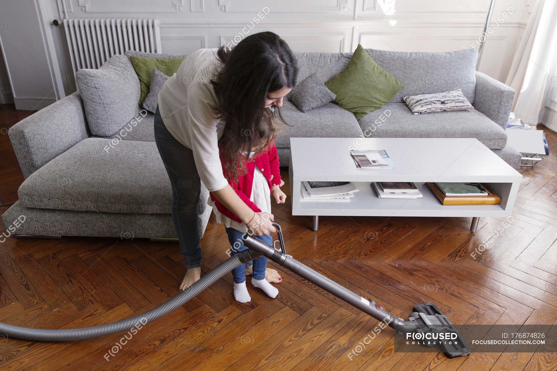 Mother Showing Her Little Daughter Hoovering The Floor Young