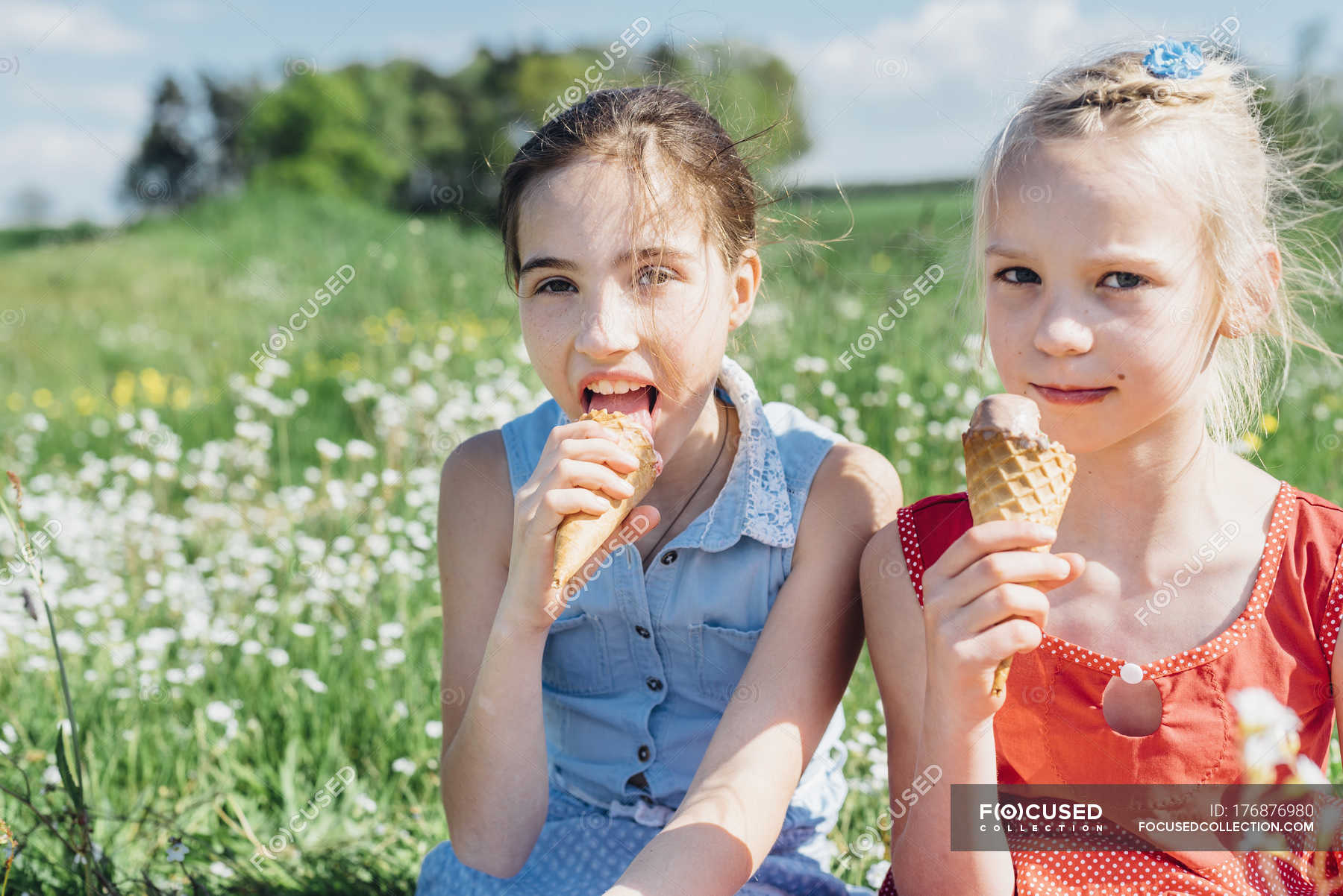 Two girls lick. Девочка ест мороженое. Дети едят мороженое на фоне травы. Счастливая девочка есть мороженое. Девочка ест мороженое вечер.