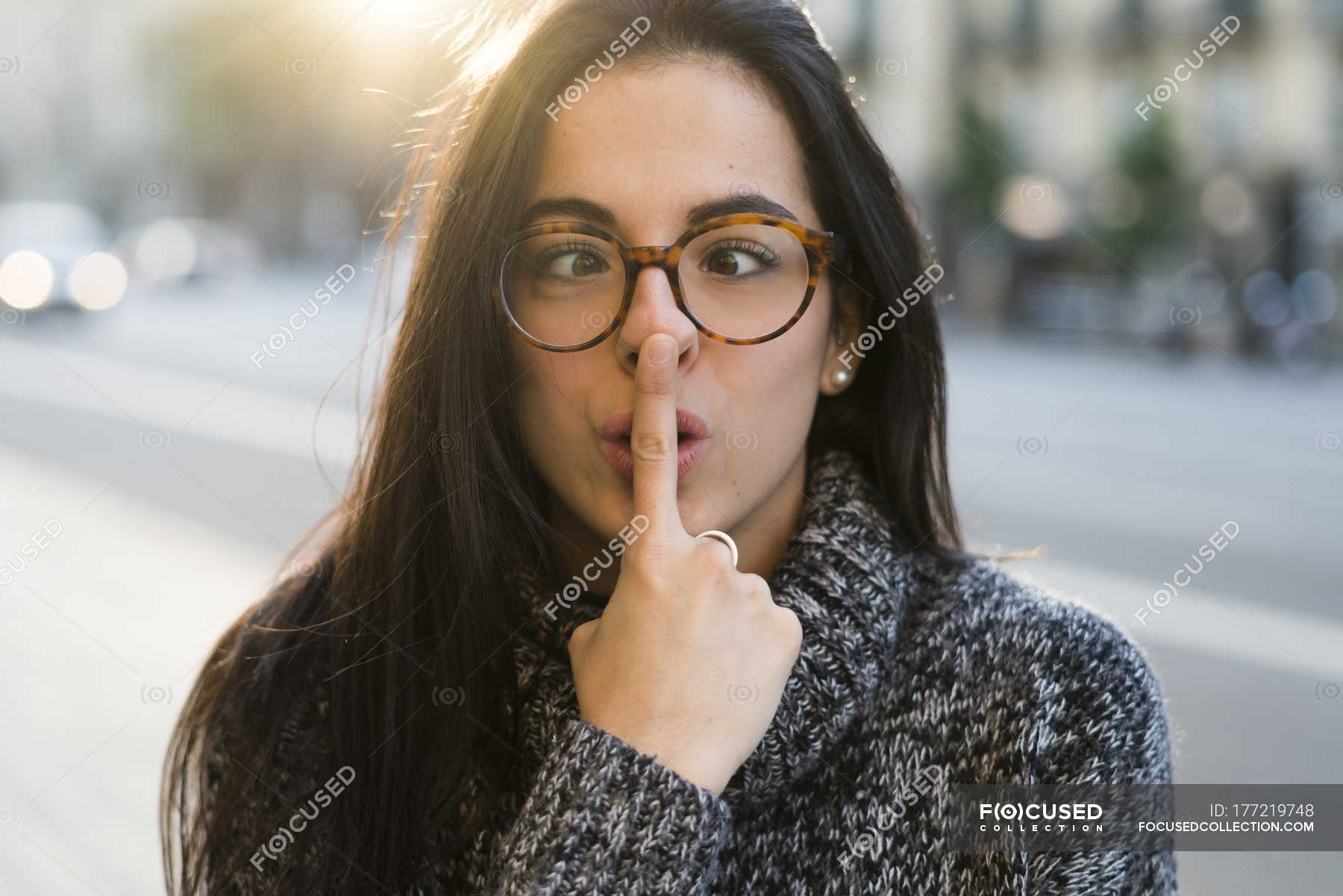 portrait-of-young-woman-with-glasses-pulling-funny-faces-front-view