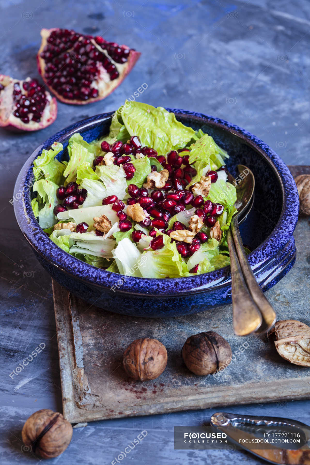 Bowl of Romaine lettuce with walnuts, pomegranate dressing and seeds ...