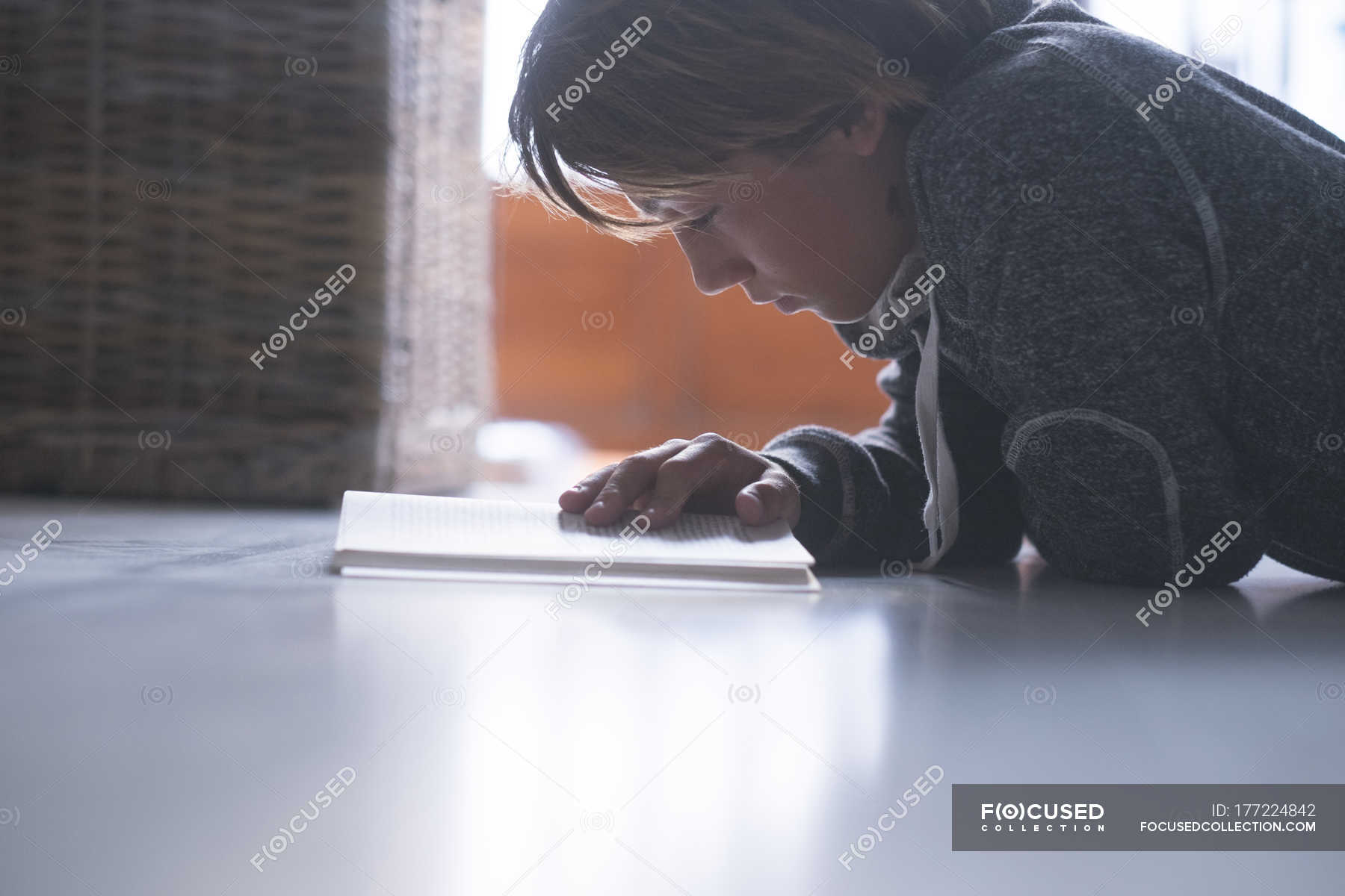 Boy lying on the floor and reading a book — Lying Down, Lying On Front