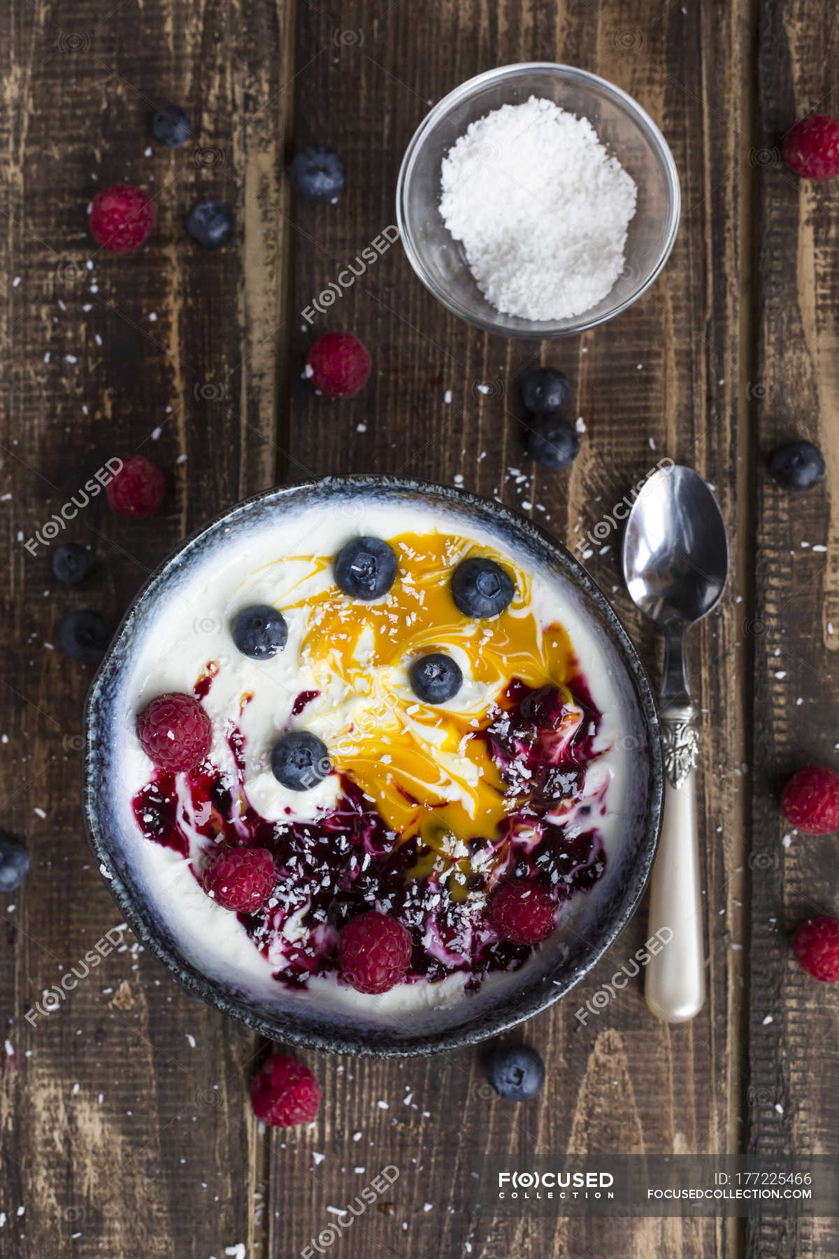 Bowl of natural yoghurt with mango pulp, grits, coconut flakes and