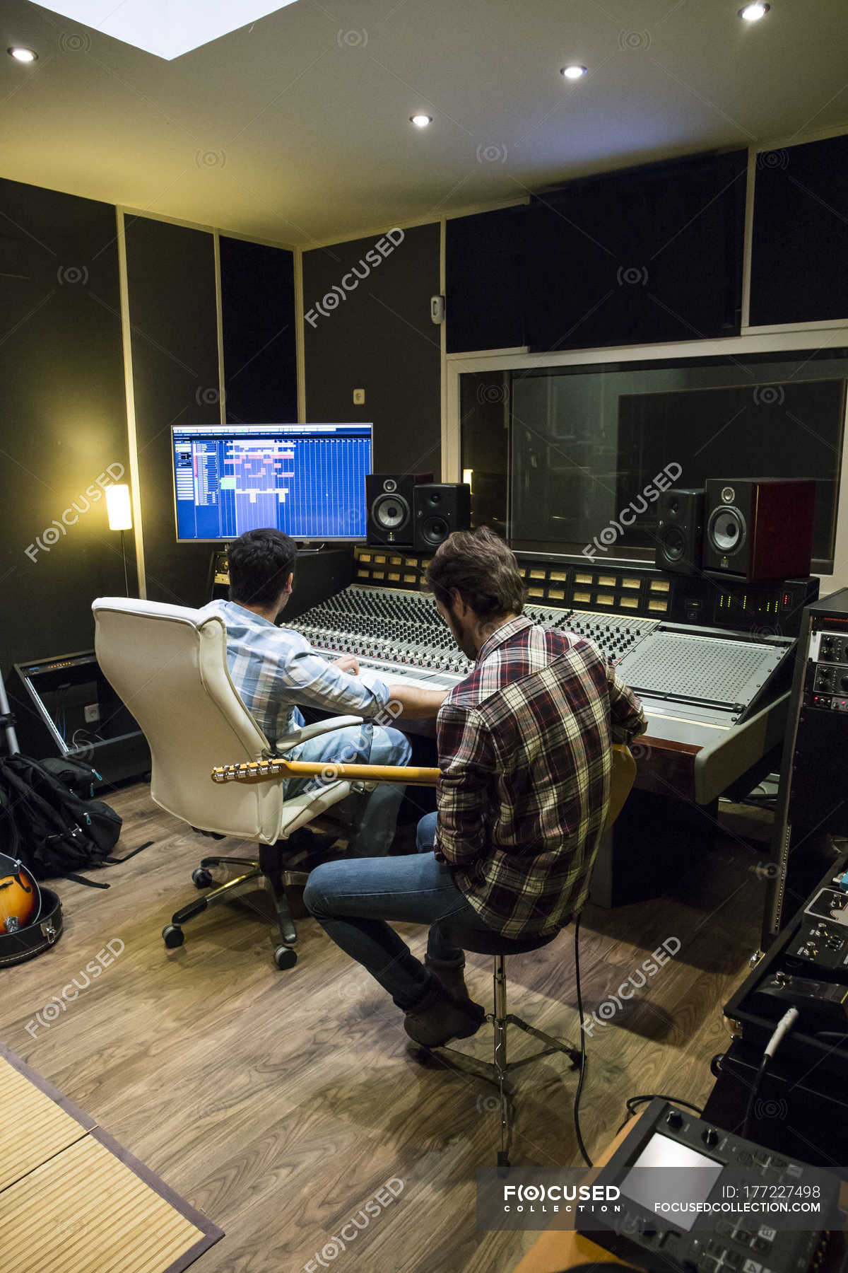 Guitar player and audio engineer in a recording studio — Two People,  sitting - Stock Photo | #177227498