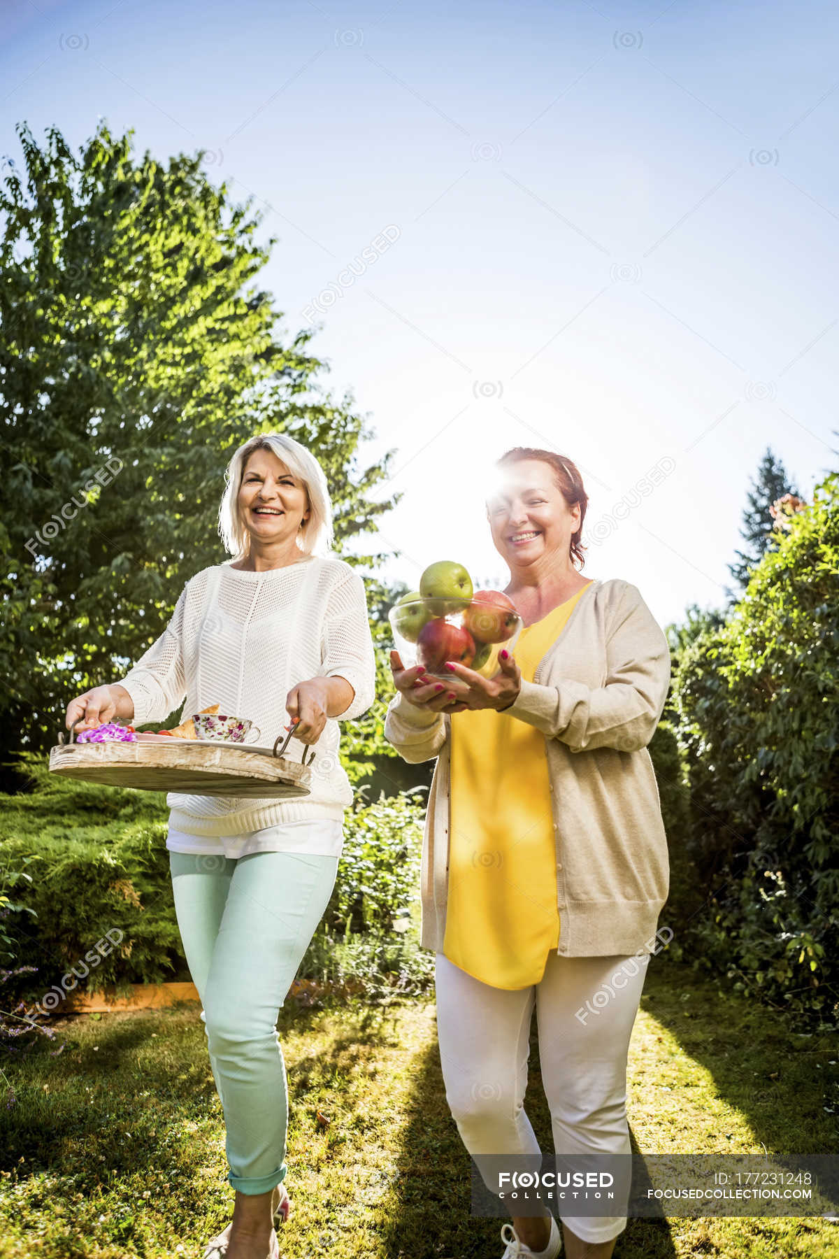 Dos Mujeres Maduras Felices Llevando Manzanas Y Bandeja En El Jardín — Amigos Disfrute Stock