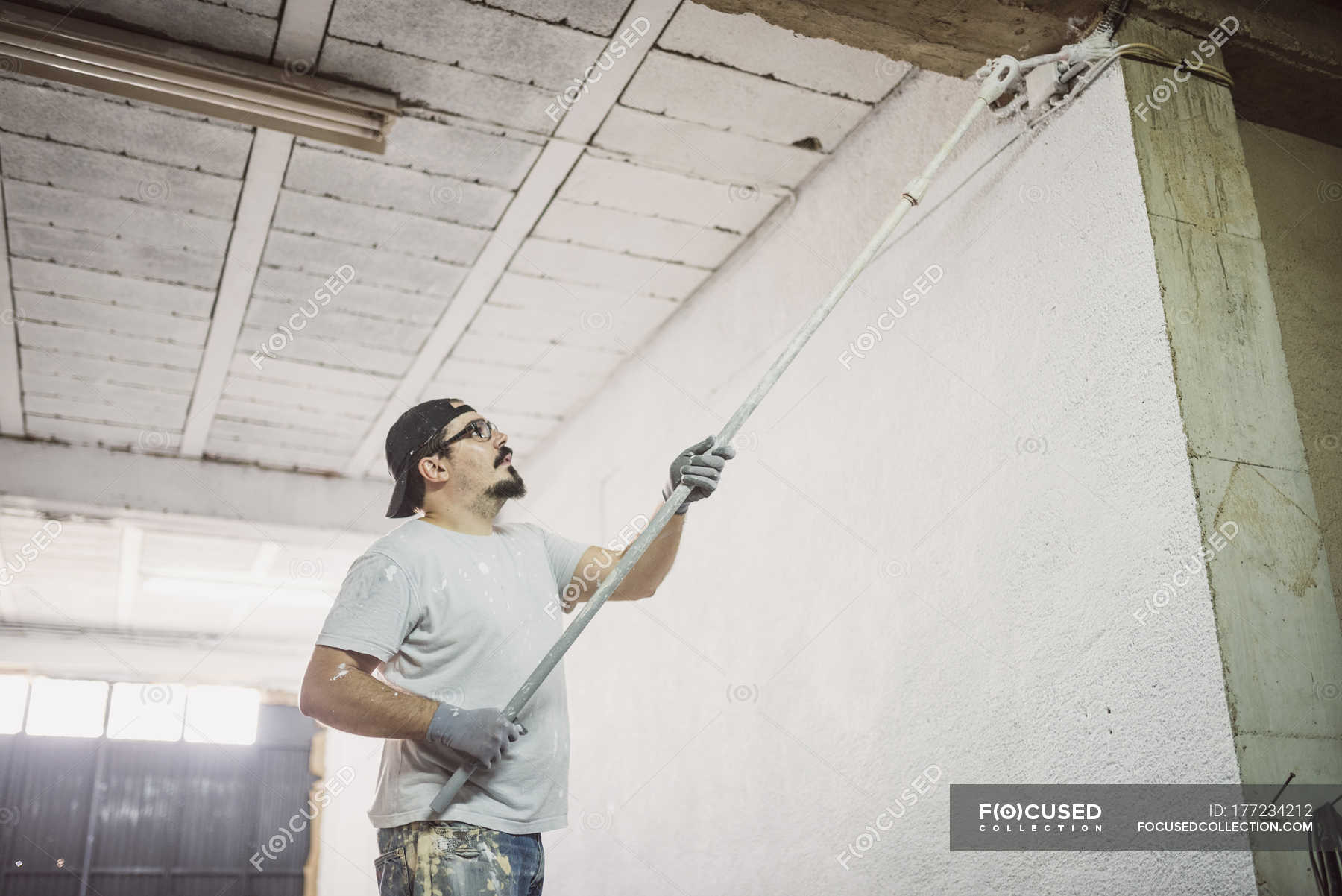 Man Painting Wall In A Garage Color Image Copy Space