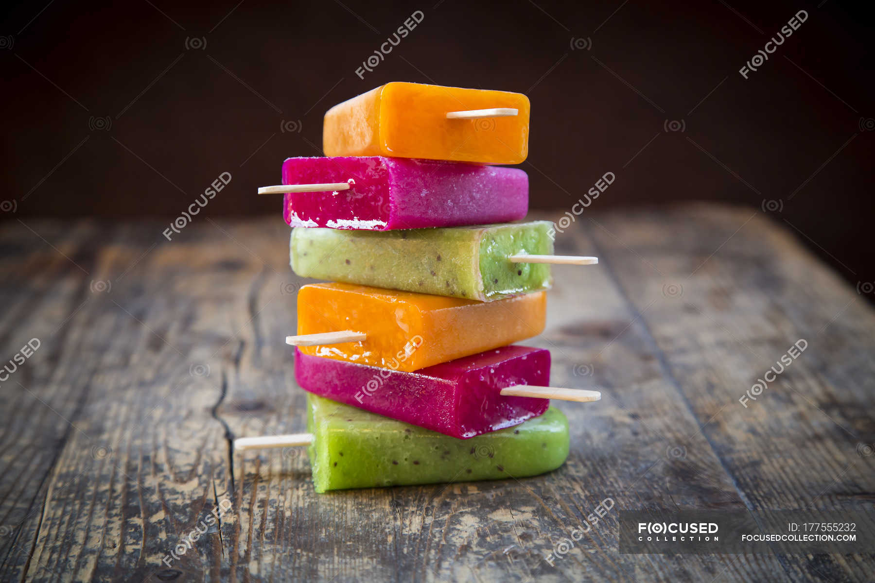 Stack of fruit smoothie ice lollies on dark wood — various, frozen - Stock  Photo | #177555232