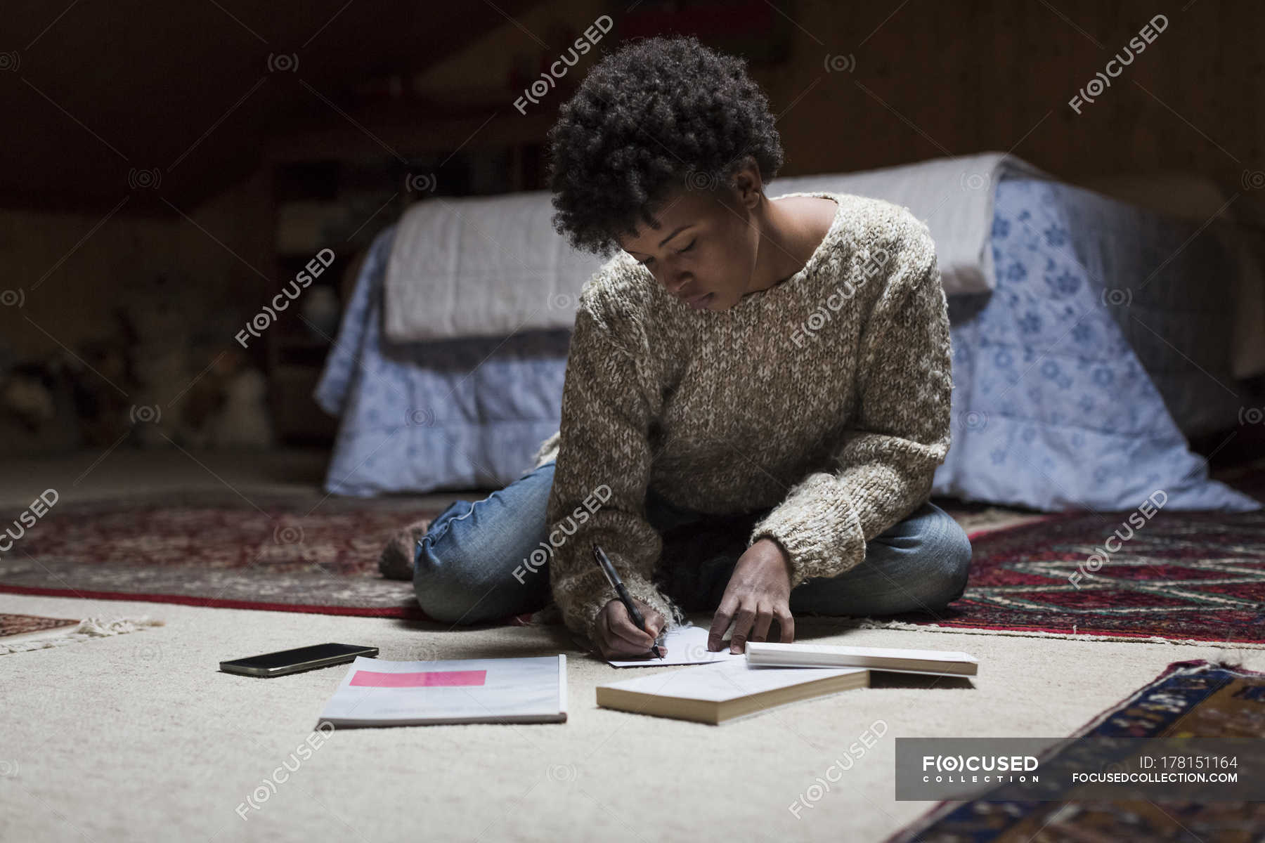 Young Woman At Home Sitting On Floor Writing Color Image One