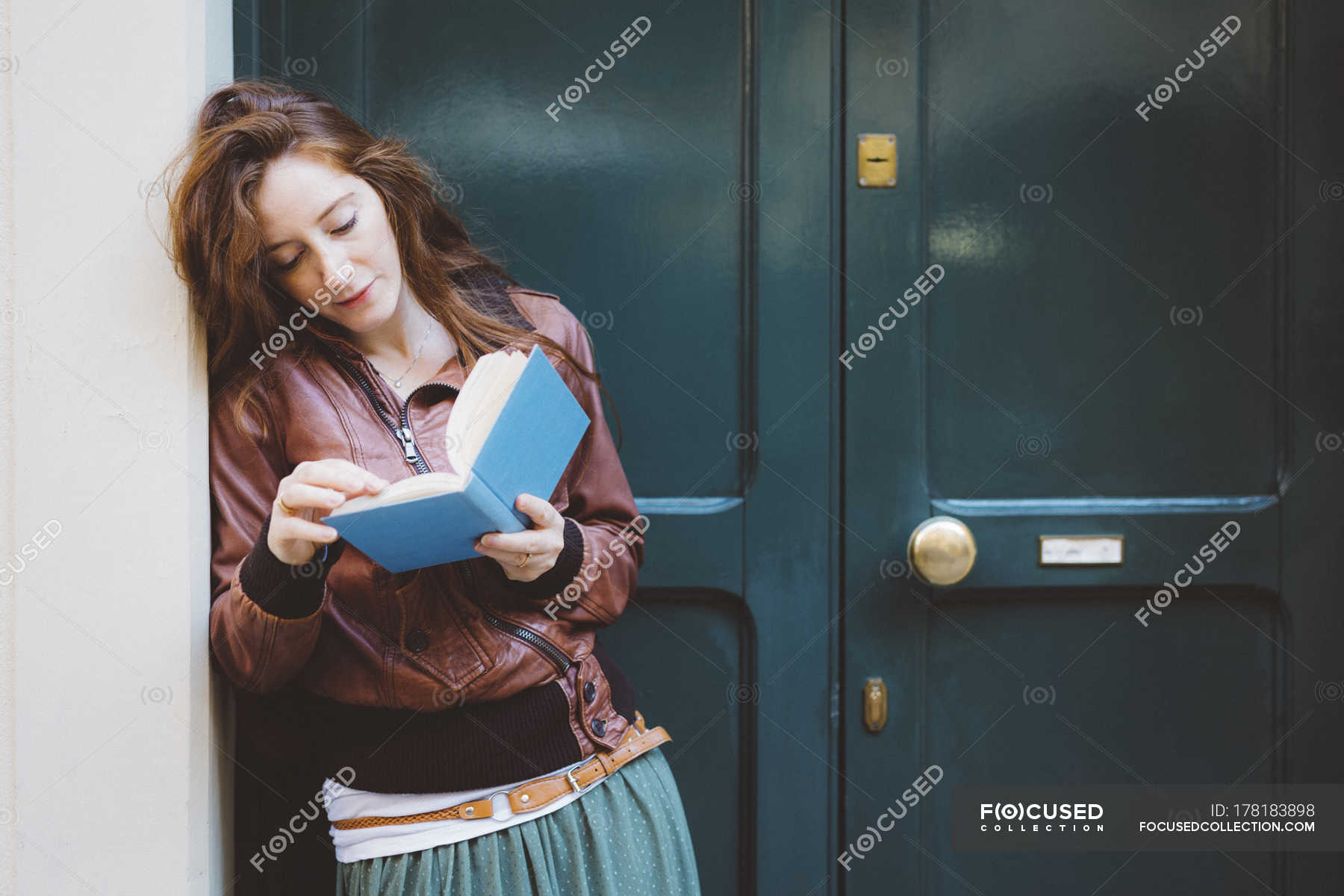 Woman Reading A Book In Front Of A Door Color Image One