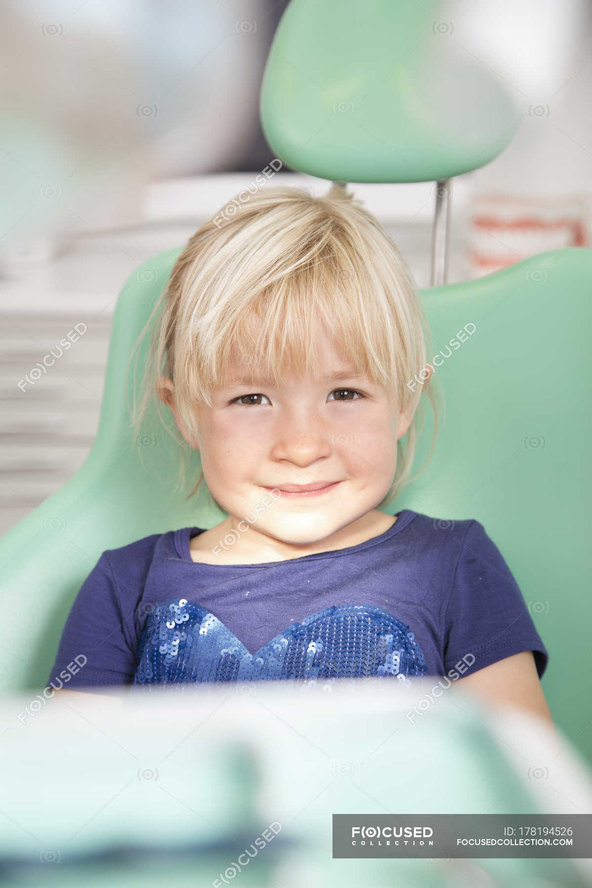 portrait-of-smiling-girl-in-dentist-s-chair-front-view-content