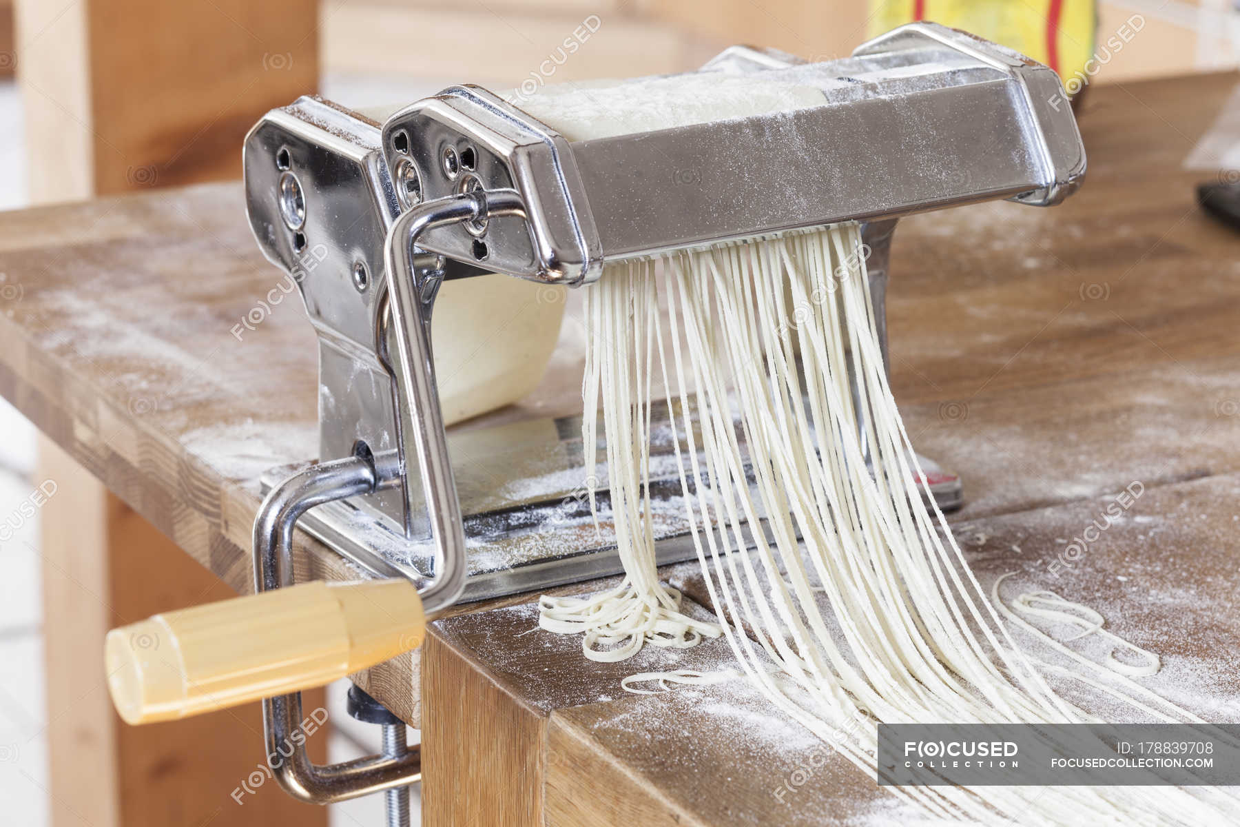 Making linguine in pasta machine — wood table, Food and drink Stock