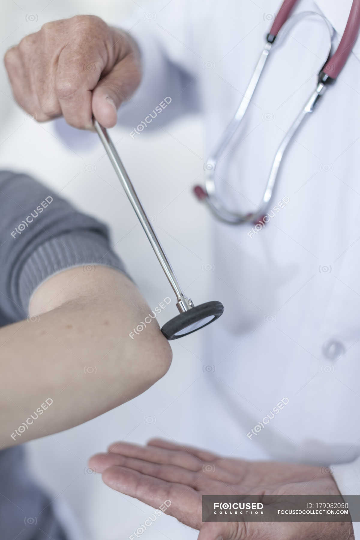 Doctor tapping patient with reflex hammer — medicine, treatment Stock