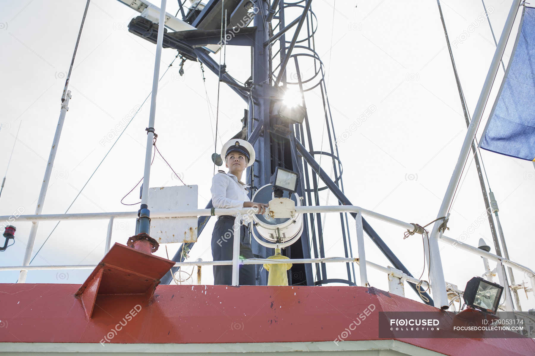 deck-officer-standing-on-deck-of-ship-watching-young-adult-stock