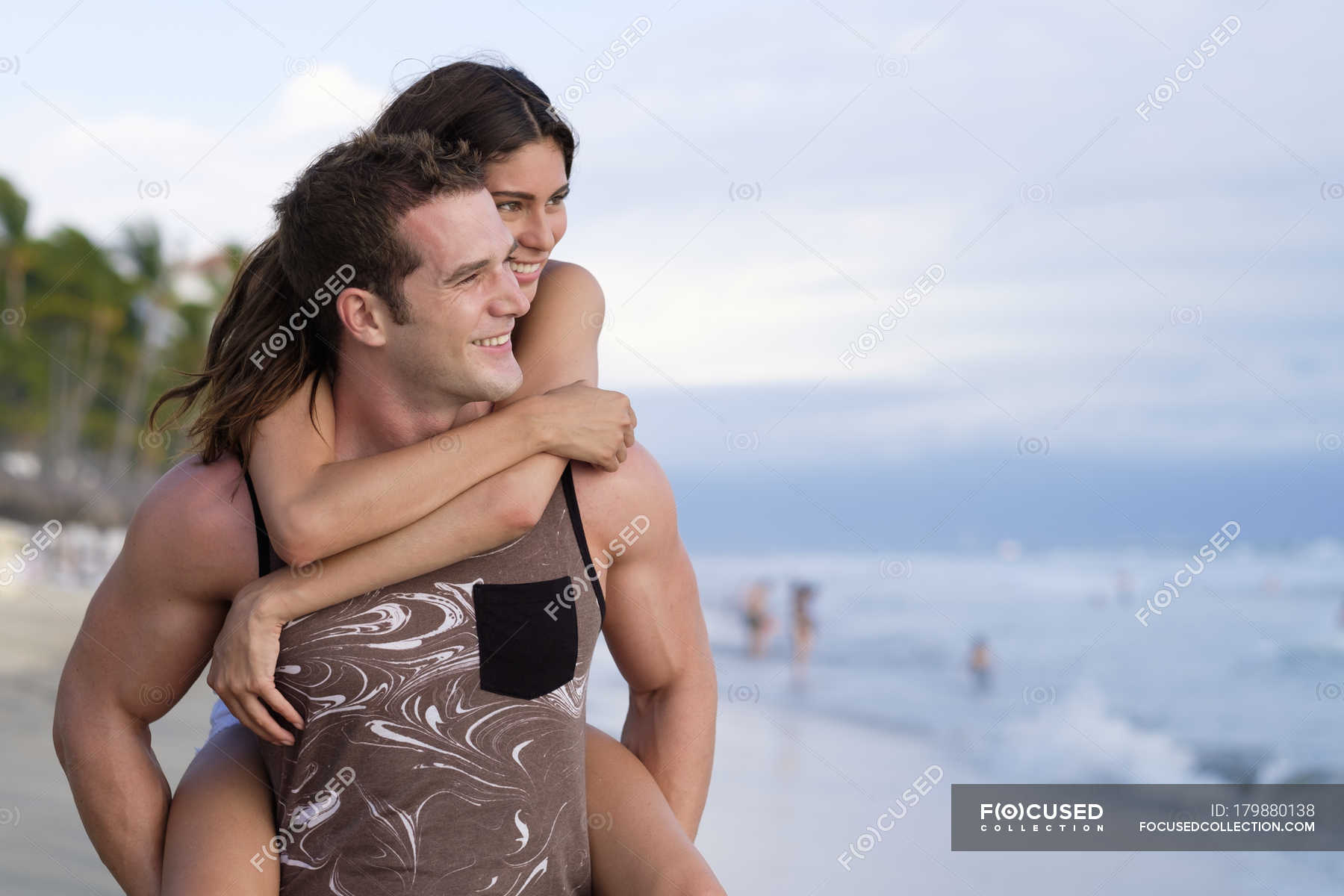 Young man giving his girlfriend a piggyback ride on the beach - a Royalty  Free Stock Photo from Photocase