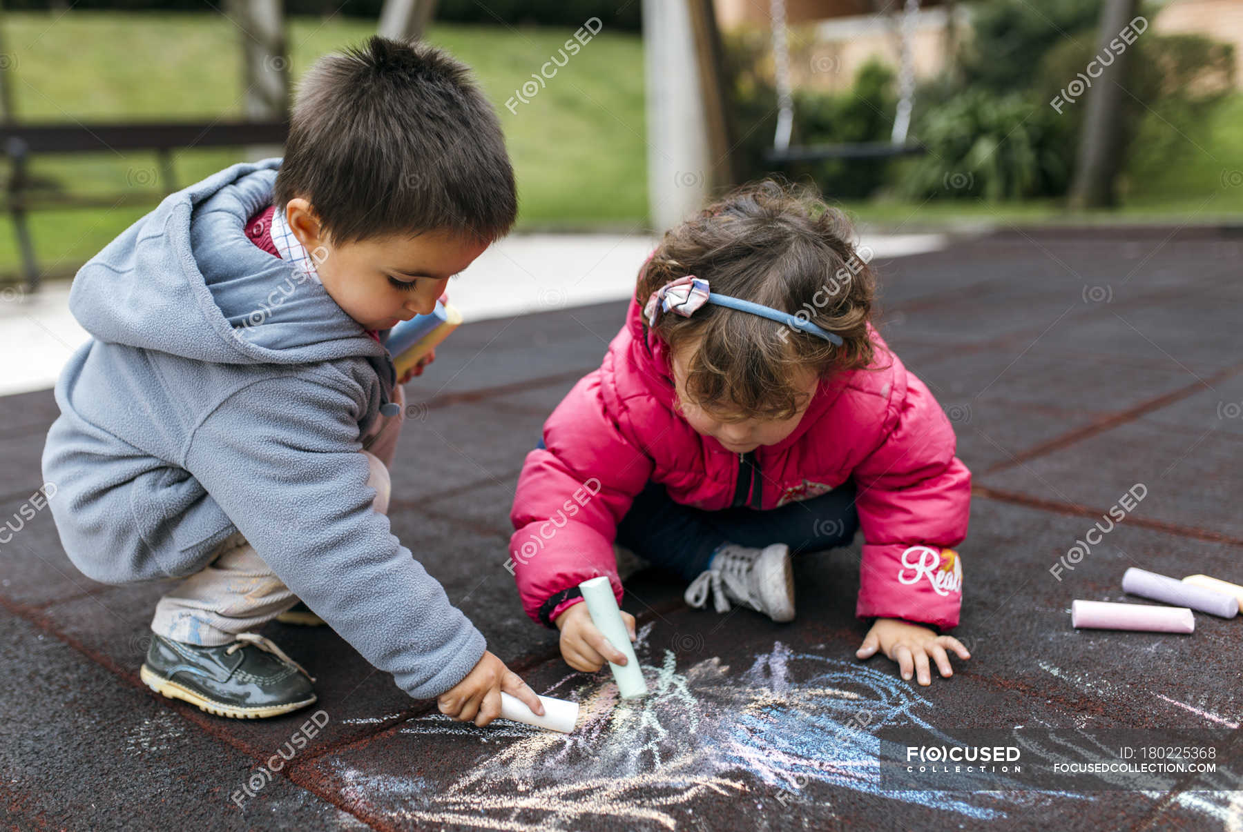 Niña y niño dibujando con tiza en el suelo — absorbido, unidad - Stock |