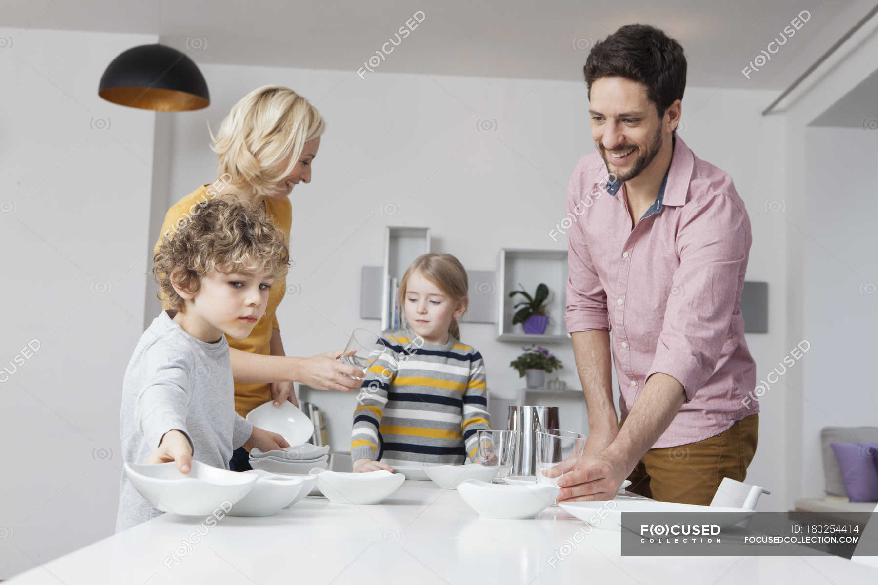 family-laying-the-table-together-children-stock-photo-180254414