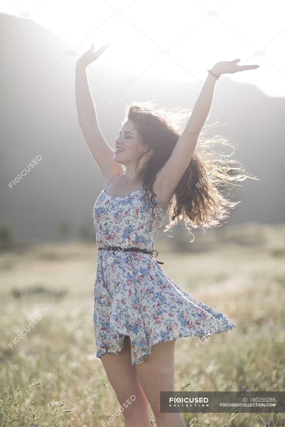 South Africa, Young woman jumping of joy in field — arm up, one person ...