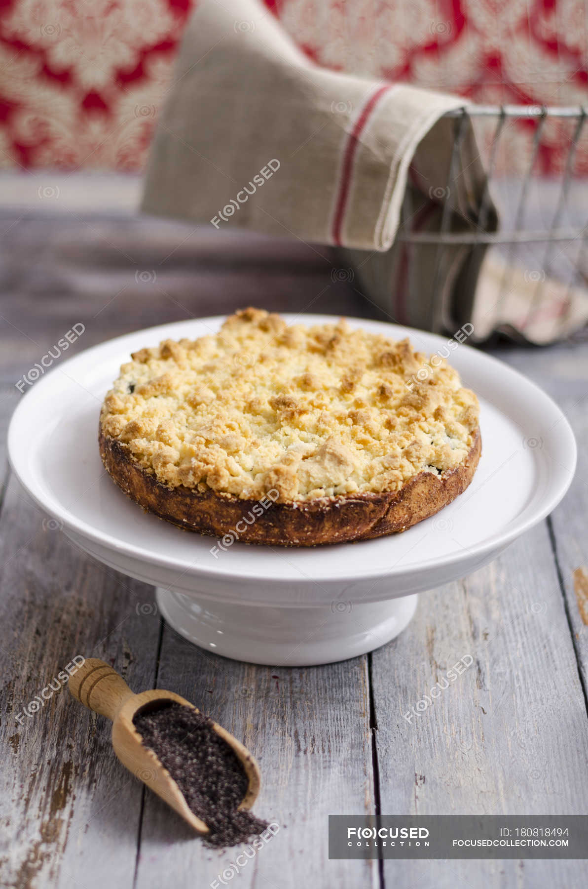 Poppy seed crumble cake on cake stand on wood — homemade, recipe
