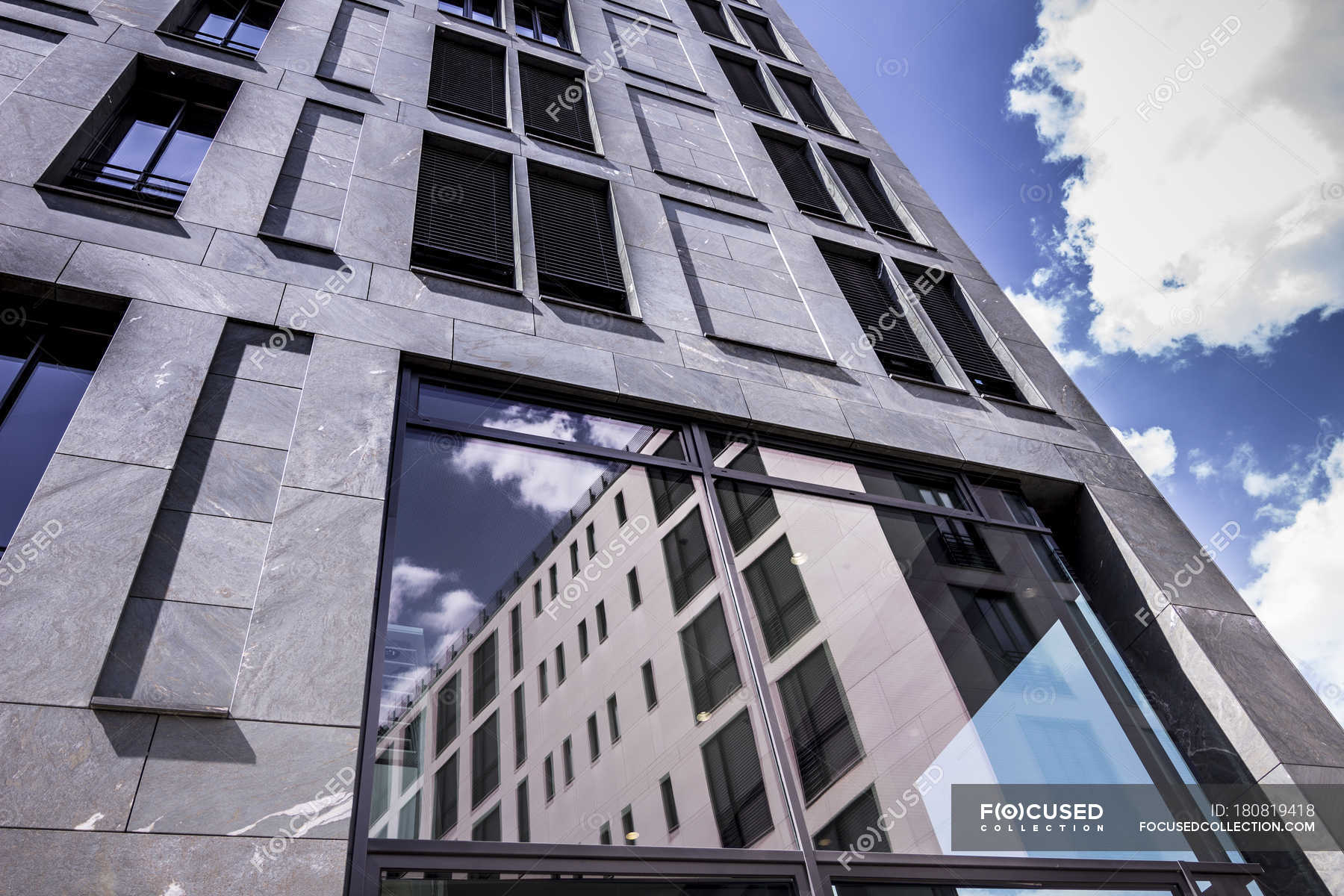 Bottom view of facade of modern office building at Berlin, Germany —  window, clouds - Stock Photo | #180819418