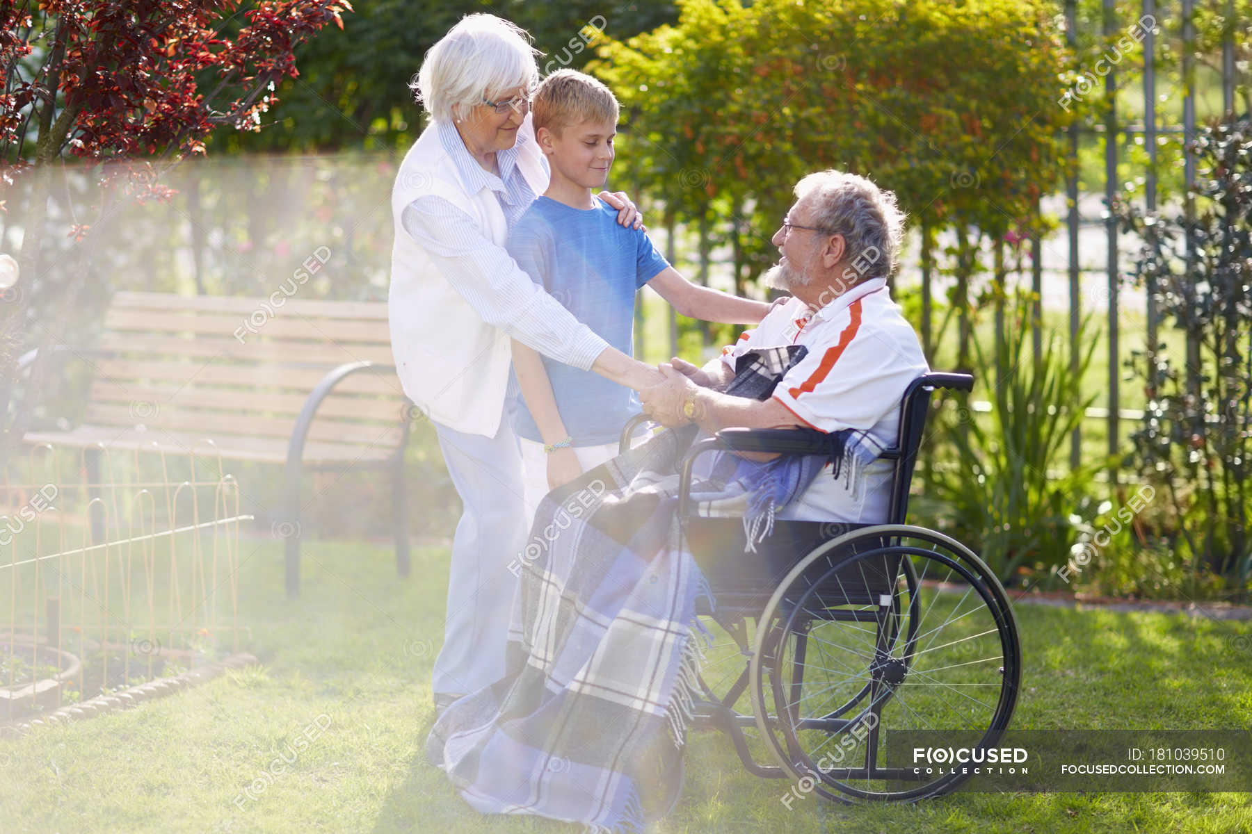 Бабушка и внук с дедушкой в инвалидной коляске на лужайке — Женский пол,Старшая женщина - Stock Photo