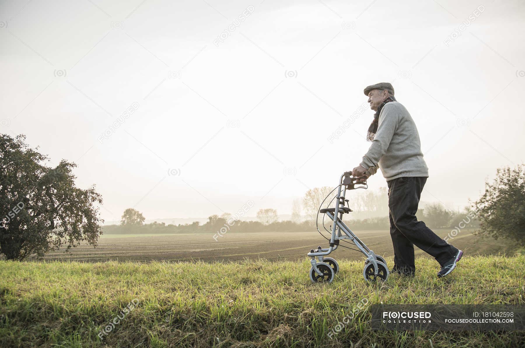 senior-man-with-wheeled-walker-walking-in-rural-landscape-the-way