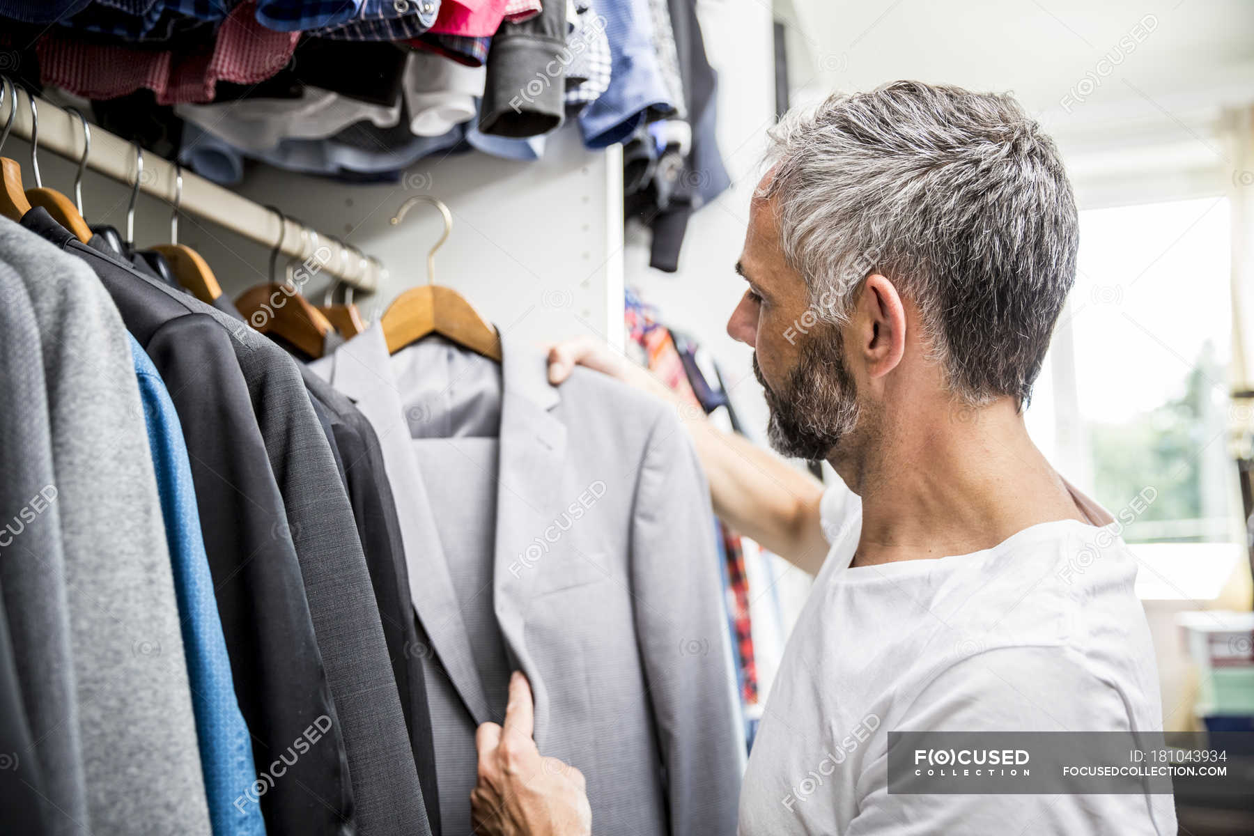 Человек выбирает одежду. Женщина выбирает платье. Делать покупки в магазине. Шоппинг в магазине одежды. Примерка платья.