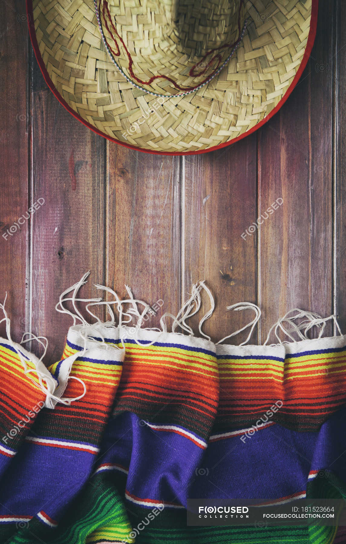 Top view of traditional Mexican serape and sombrero on wooden