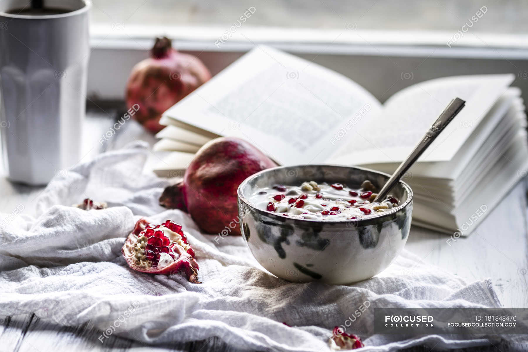 Healthy Breakfast With Pomegranate In Yogurt Coffee And Opened Book Appetizing Meal Stock Photo
