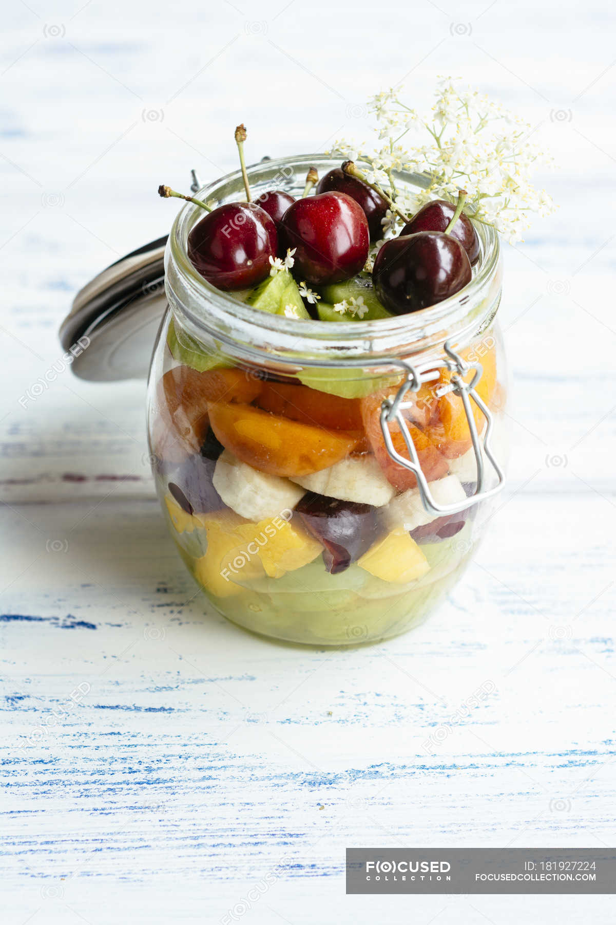 Fruit salad in jar with grapes, mango, banana, cherries, apricot, kiwi